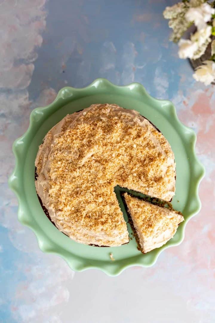 coconut coffee cake on the table with flowers in the backdrop