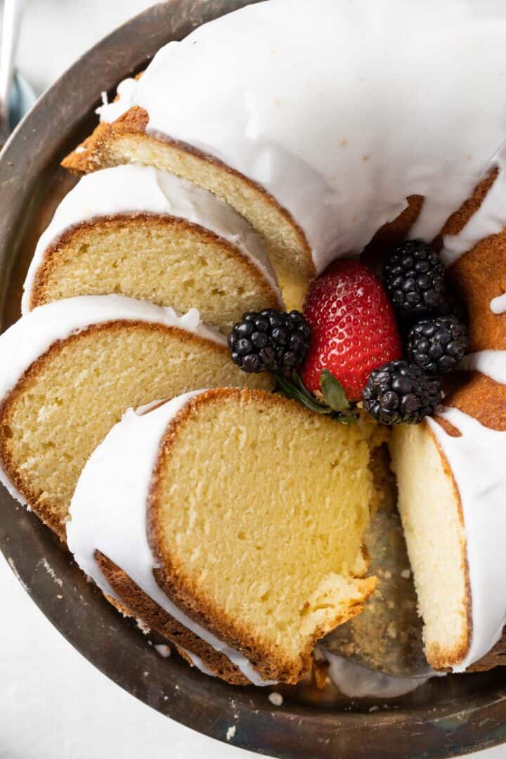 slices of old fashioned sour cream pound cake sitting over an antique cake plate.