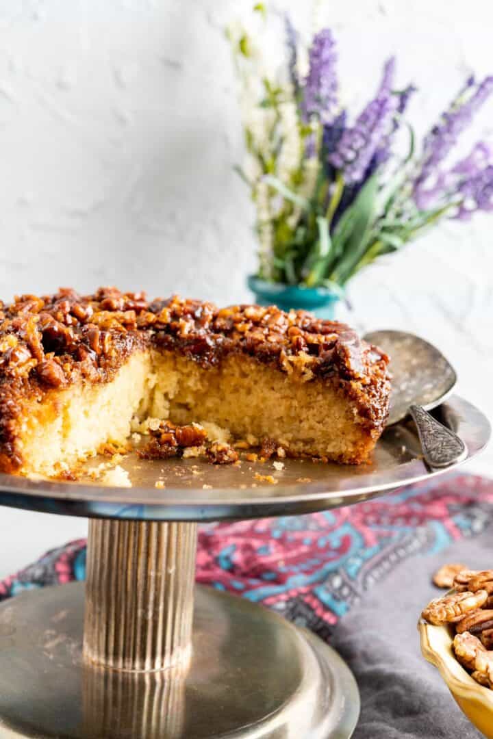 pecan upside down cake on the rustic cake plate closeup shot with silver spoon.