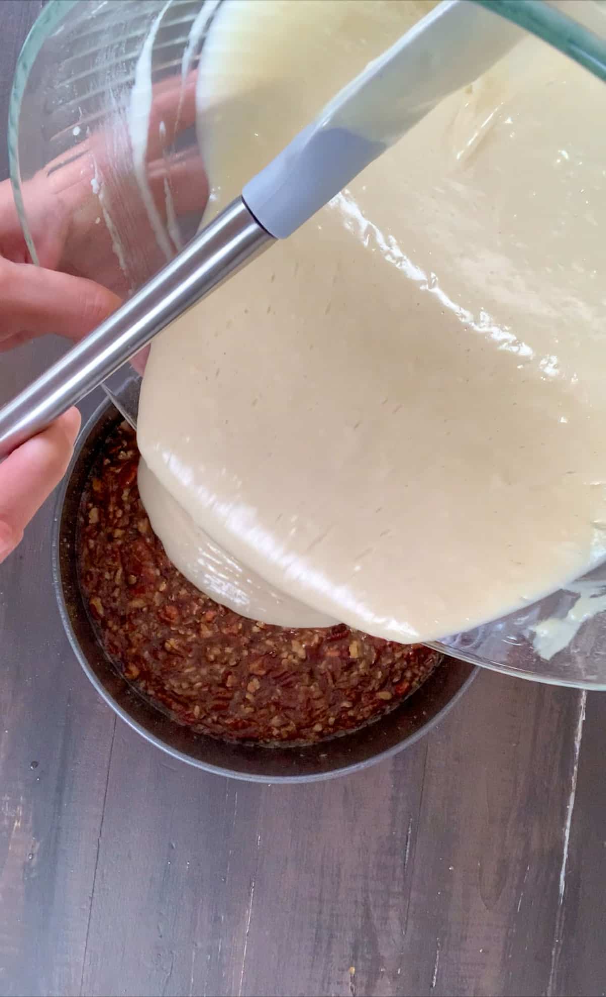 Pouring the cake batter into the greased cake pan with caramel icing in the bottom. 