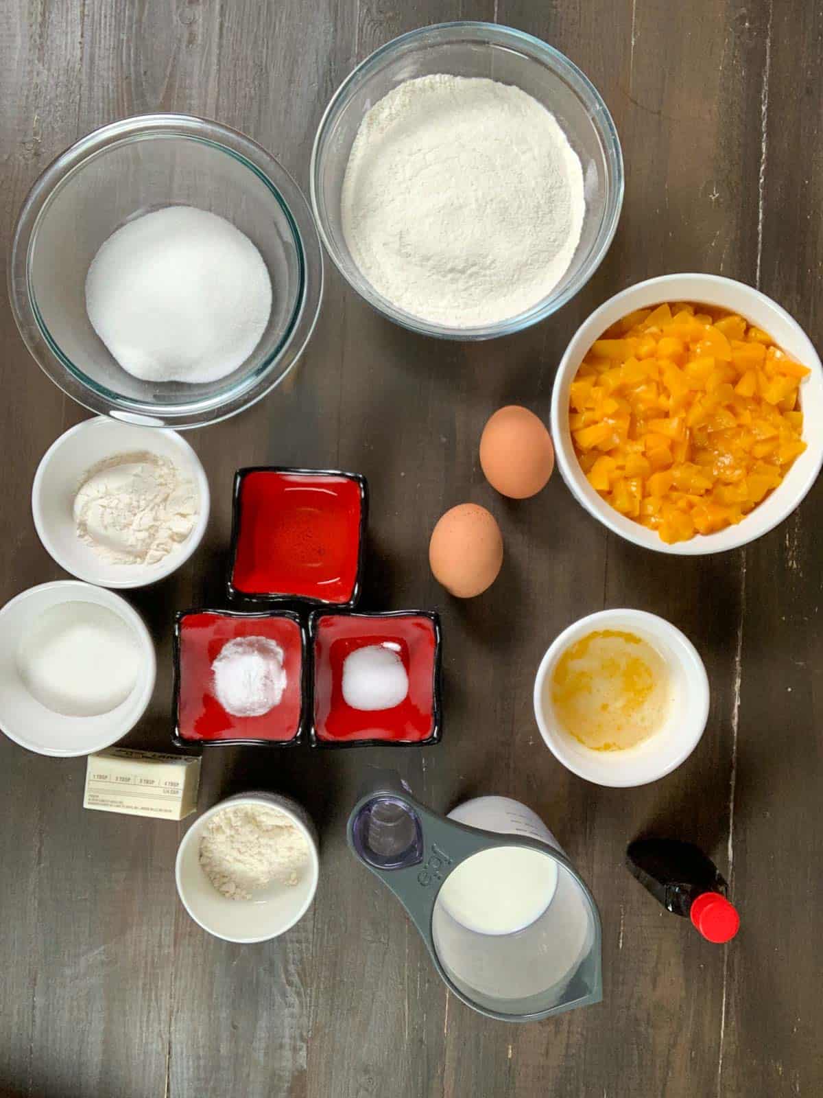 ingredients set on the table for peach cobbler muffins.