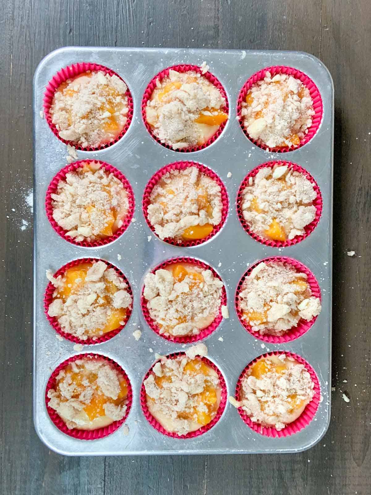peach cobbler muffins in the muffin tray ready to go in the oven. 