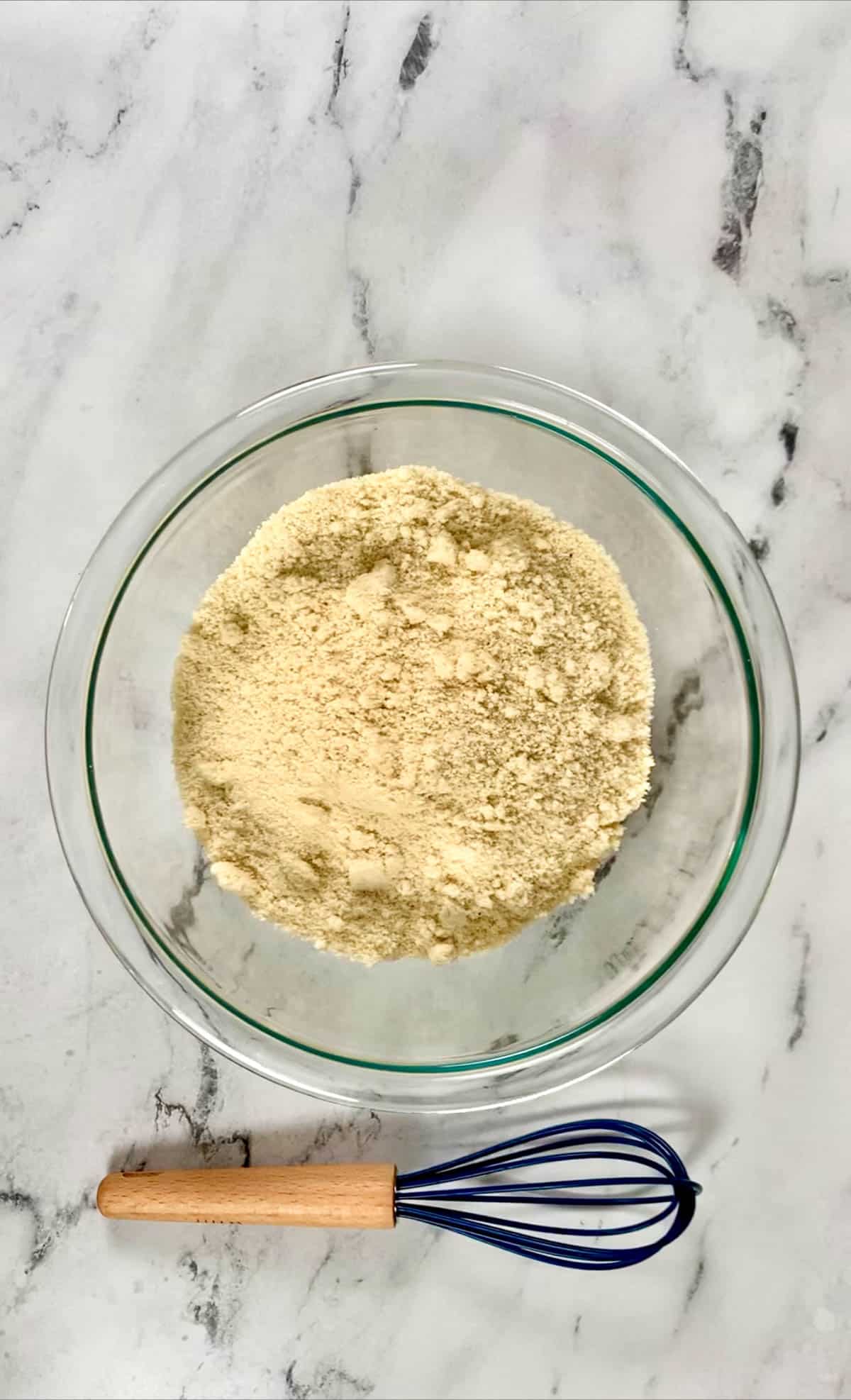 Almond flour in a medium sized bowl with a whisk.