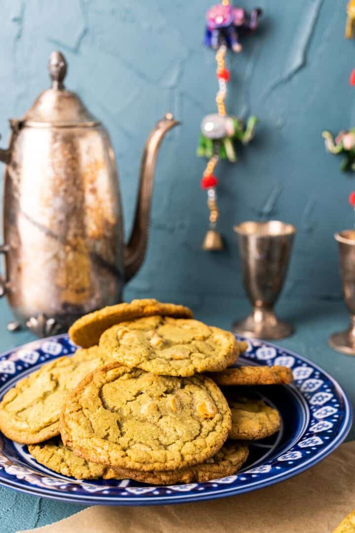 an antique blue and white plate filled with matcha cookies with silver tea pot and cups in the backdrop.