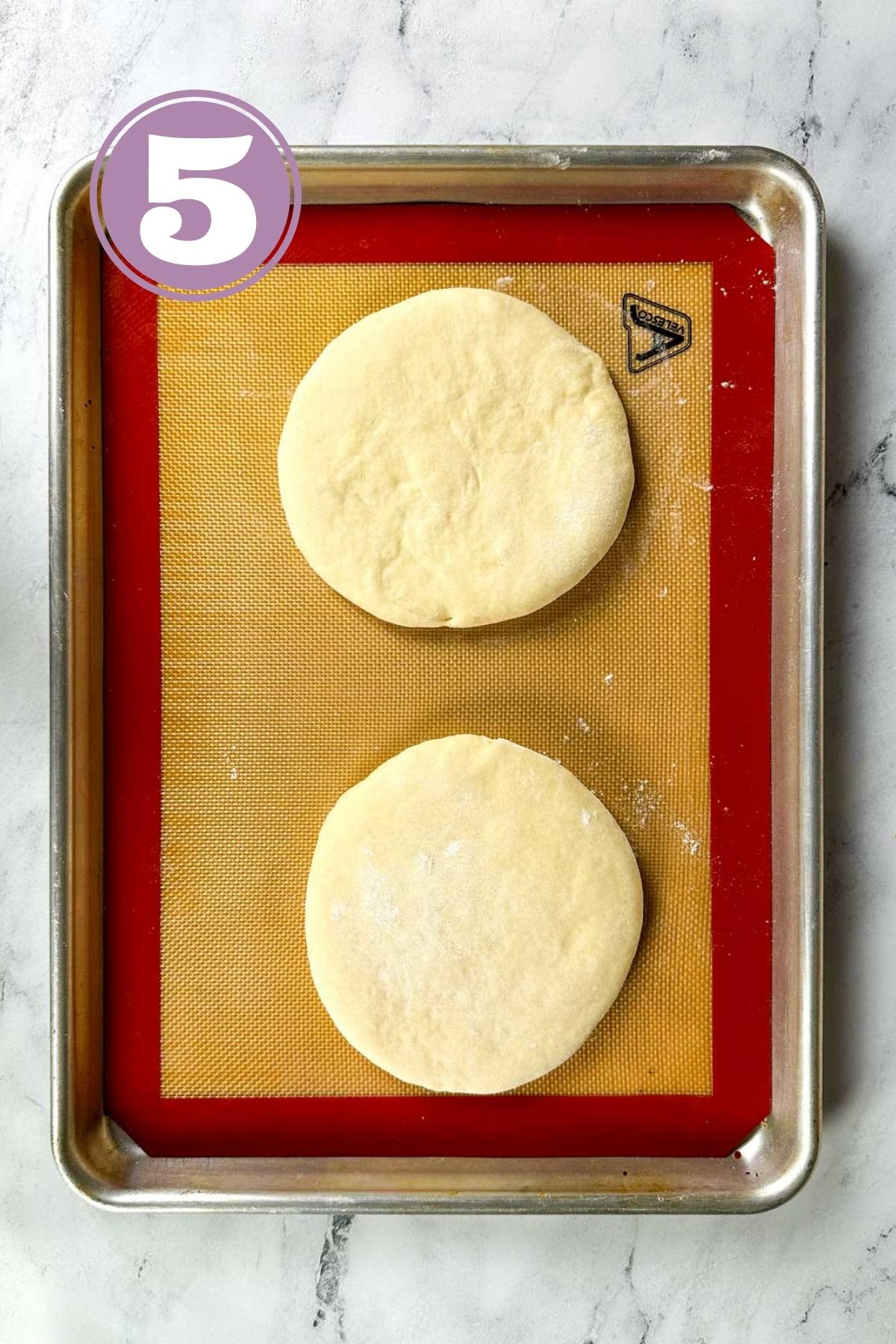proofing two turkish bread loaves on the silicone mat in a baking tray.