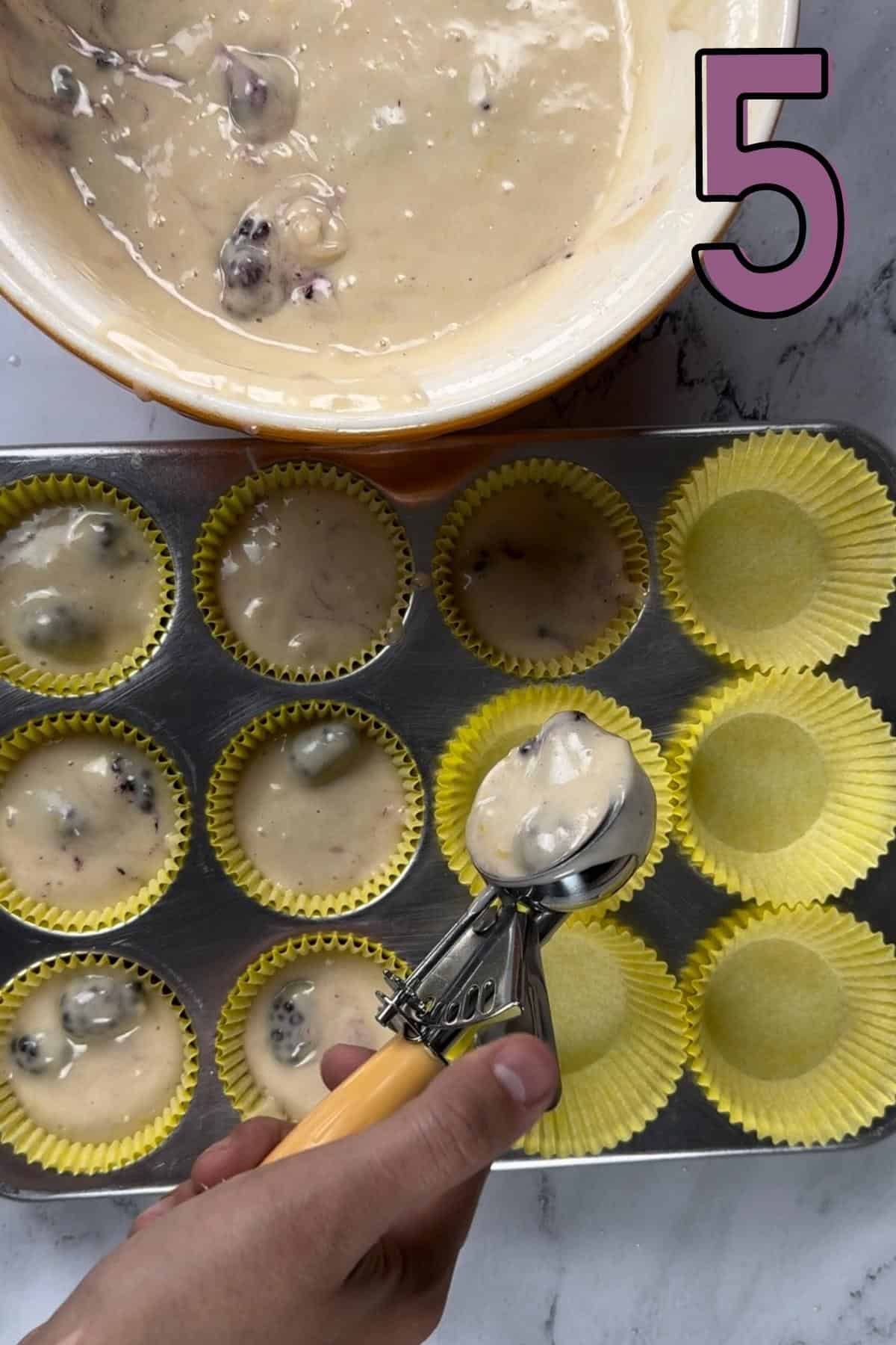Filling up the muffin liners with batter using an ice-cream scoop.