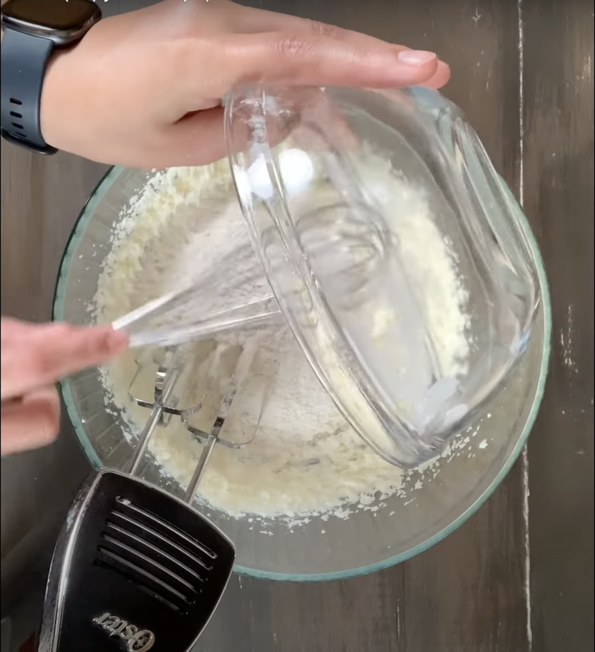 adding the flour to the creamy butter in the mixing bowl for the california pizza kitchen butter cake.