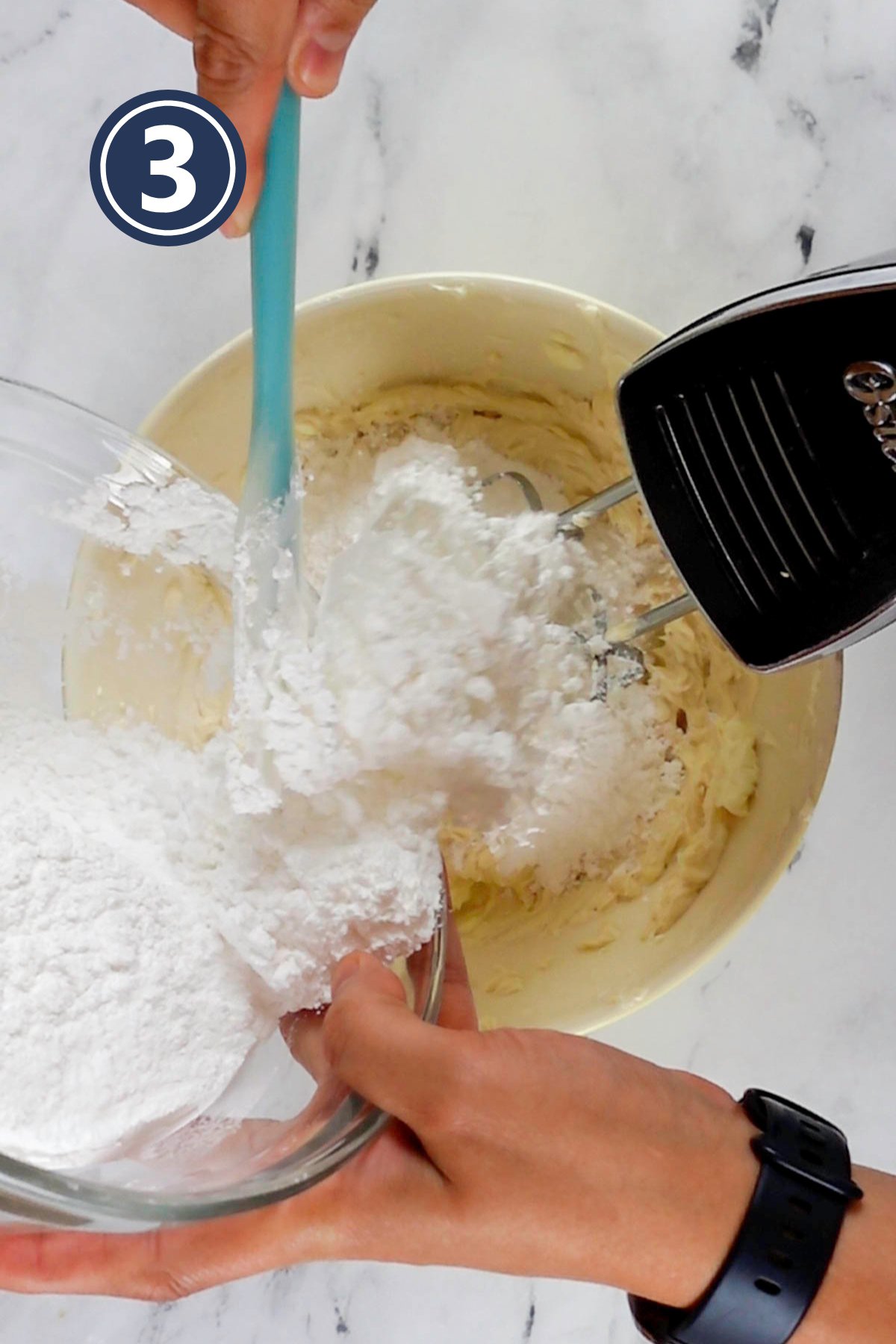 adding powder sugar in the cream cheese to make frosting.