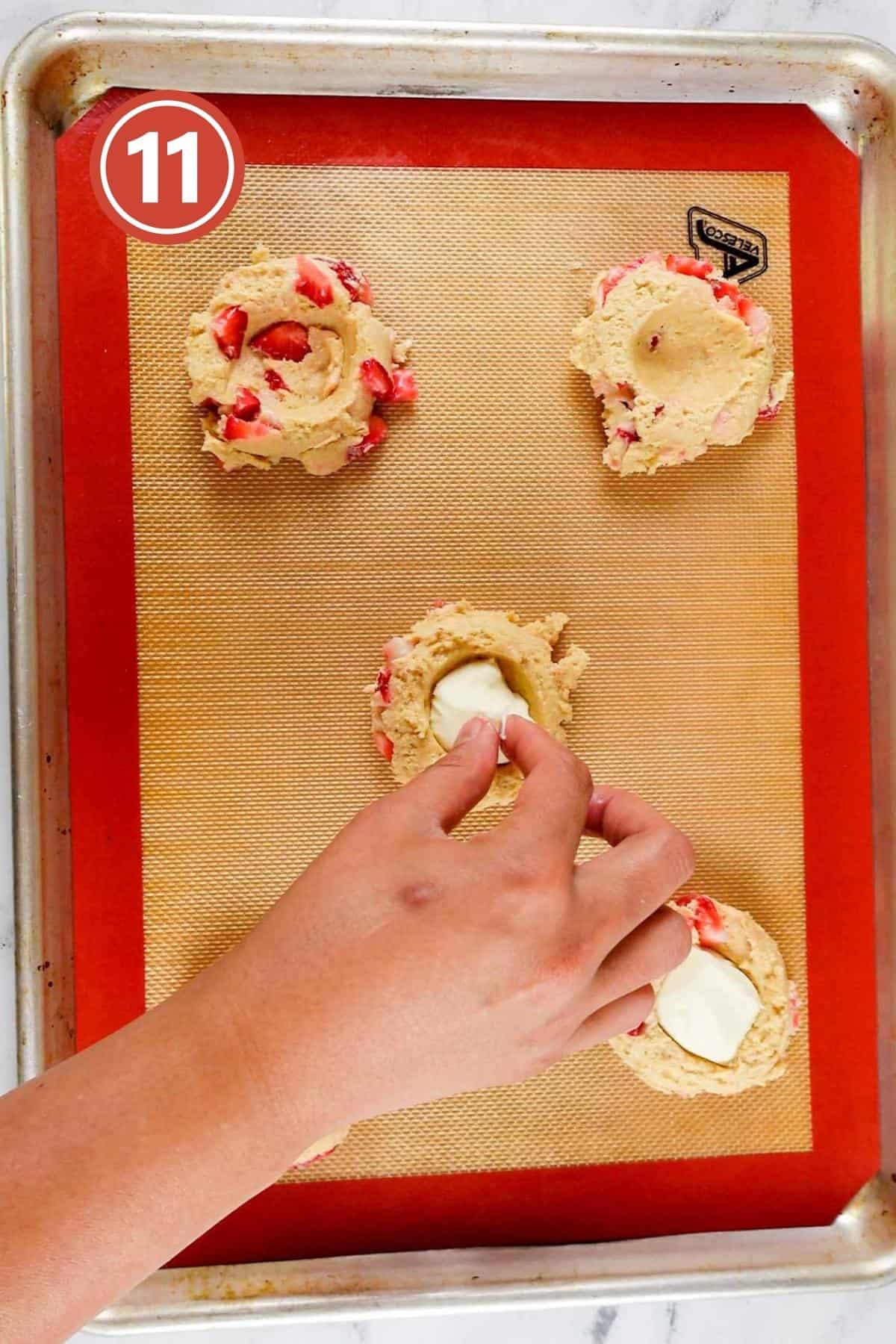 placing cream cheese dollop in the middle of the cookies.