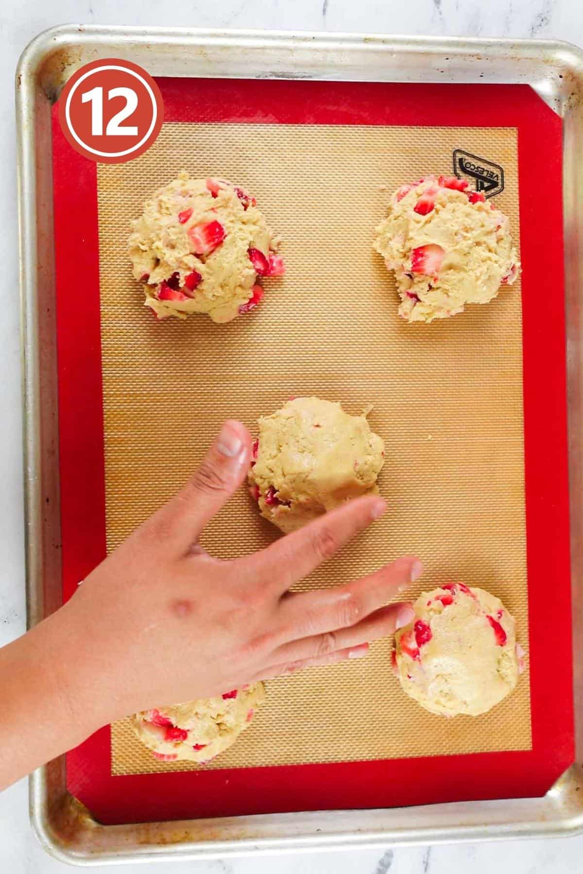 putting more cookies batter on the top of the cookie.