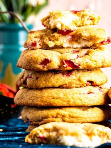many strawberry cheesecake cookies stacked upon each other.