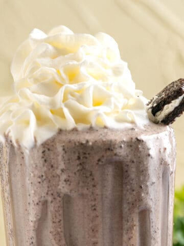 banana oreo milkshake with an oreo biscuit on the side.
