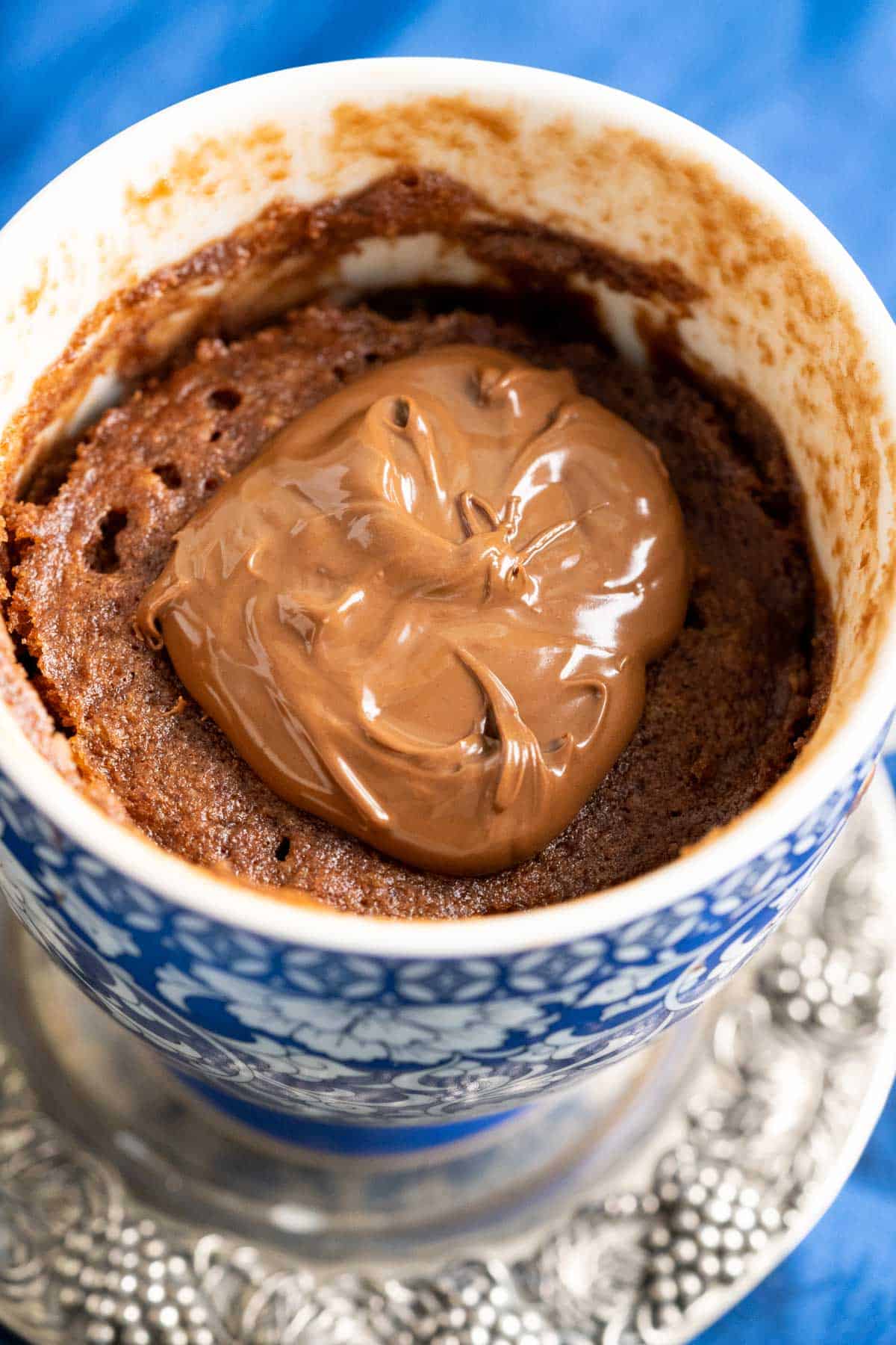 close shot of dollop of chocolate hazelnut spread on a chocolate mug cake.