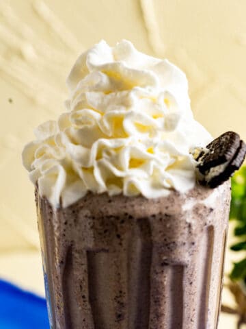 close shot of a glass with oreo shake and whipped cream on the top of shake.