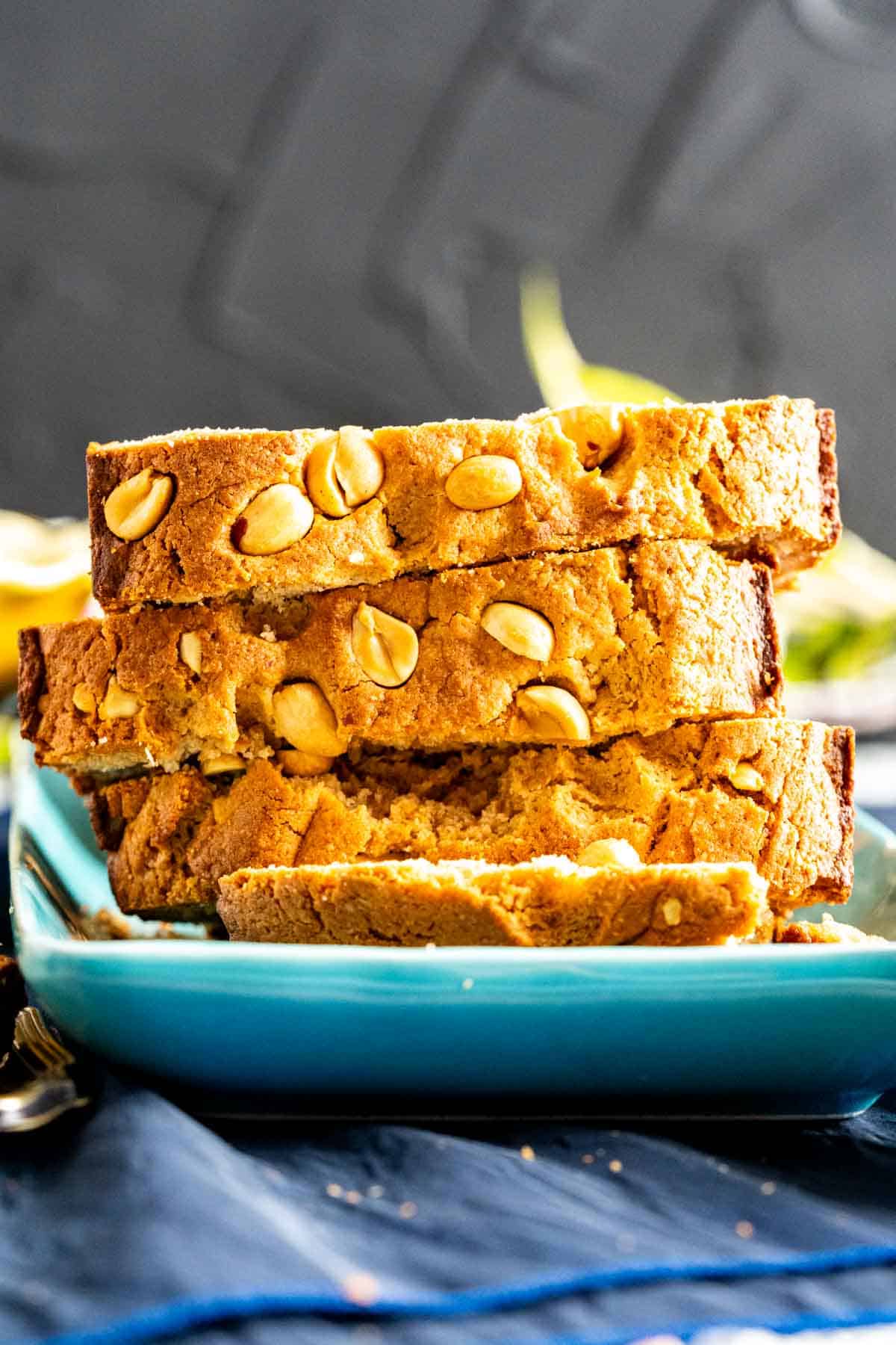 Overlapped slices of peanut quick bread with peanuts sprinkled on the top crust.