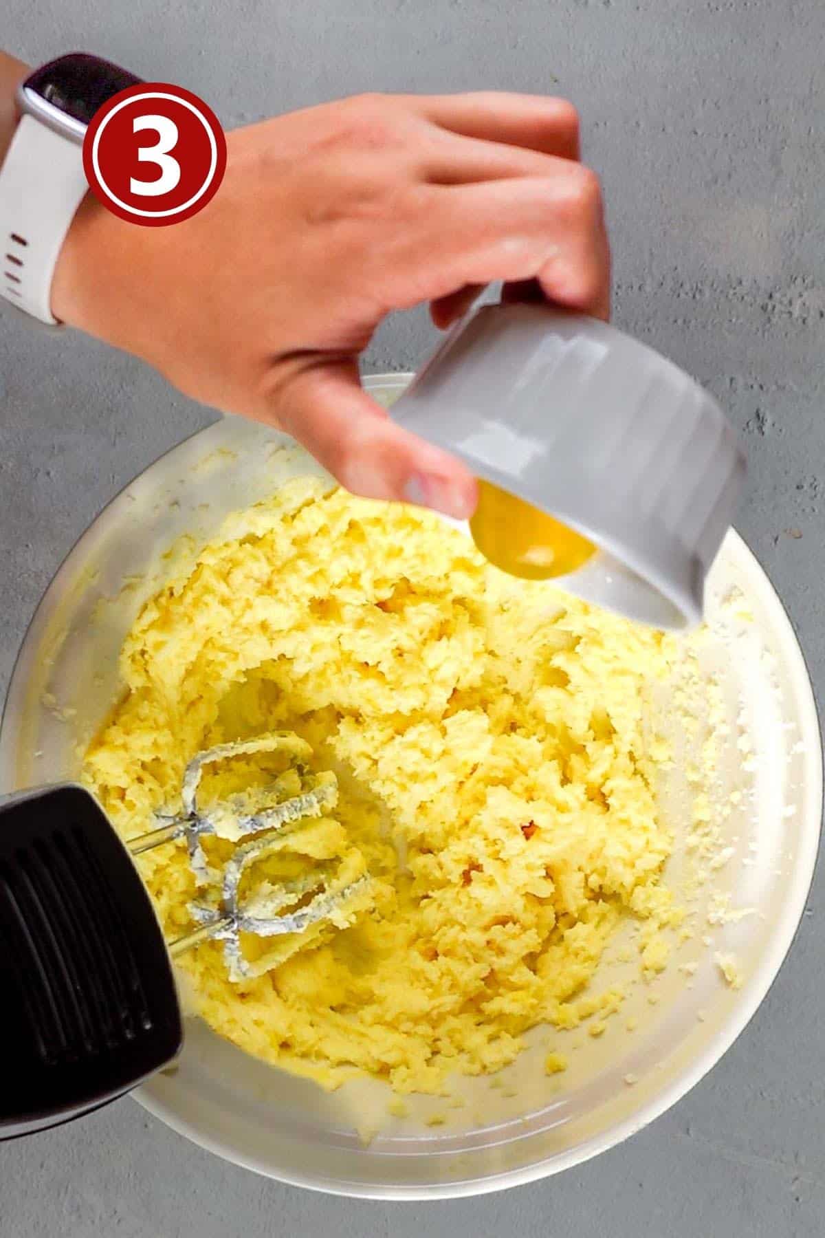 adding the egg yolks into the butter and sugar mixture.