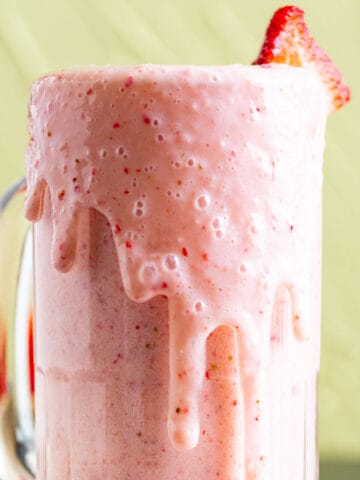 strawberry banana milkshake in a cup.
