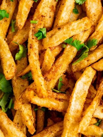 close shot of the long french fries quoted in the spices.