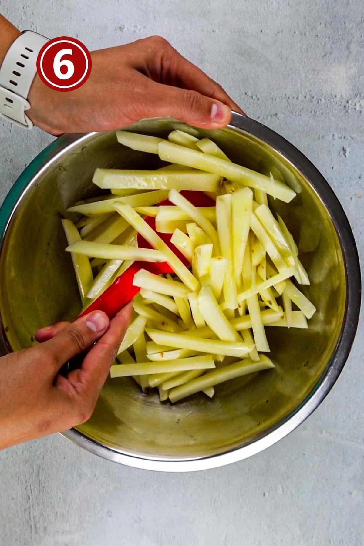 tossing the fries in the olive oil.