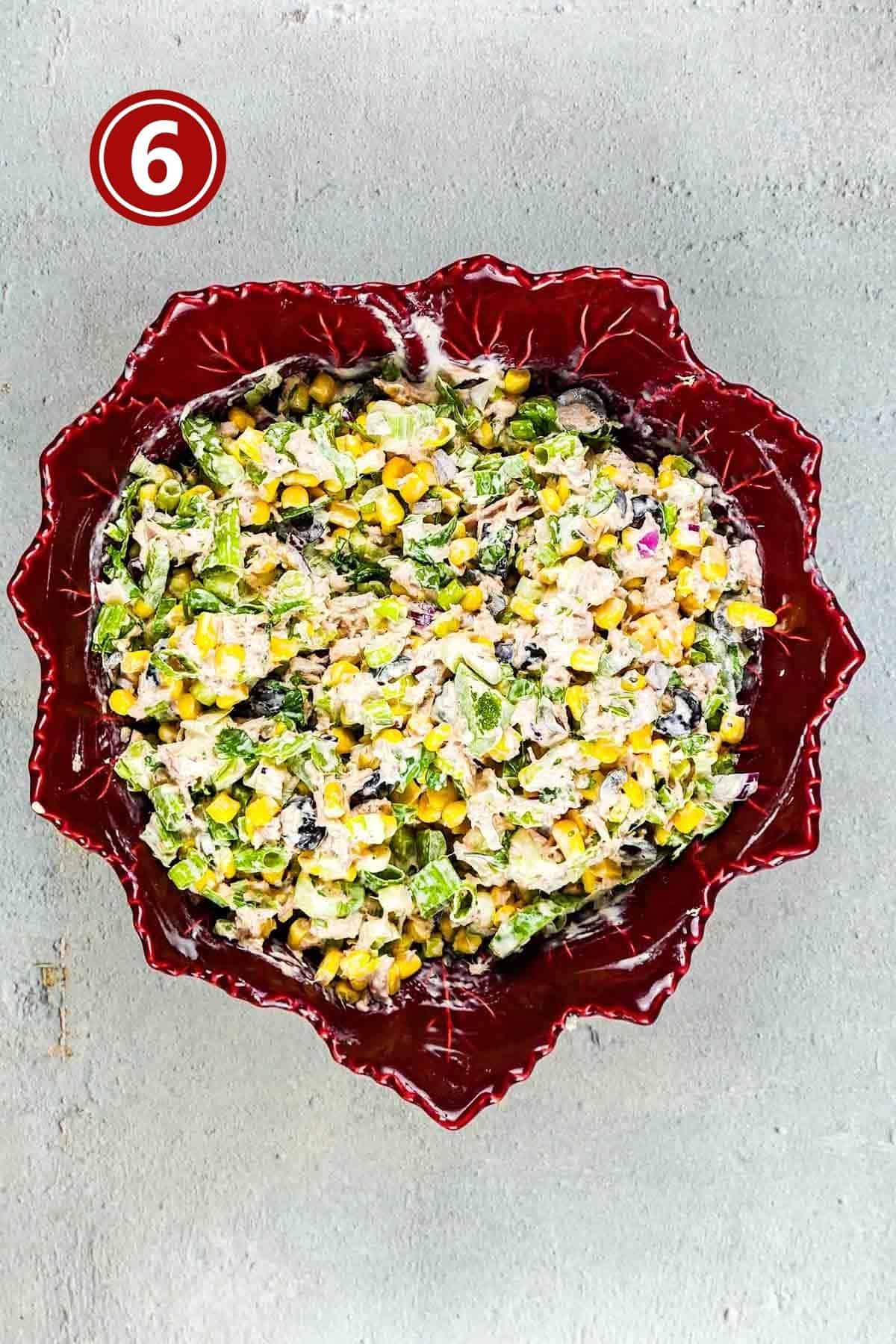 prepared tuna corn salad in a red bowl.
