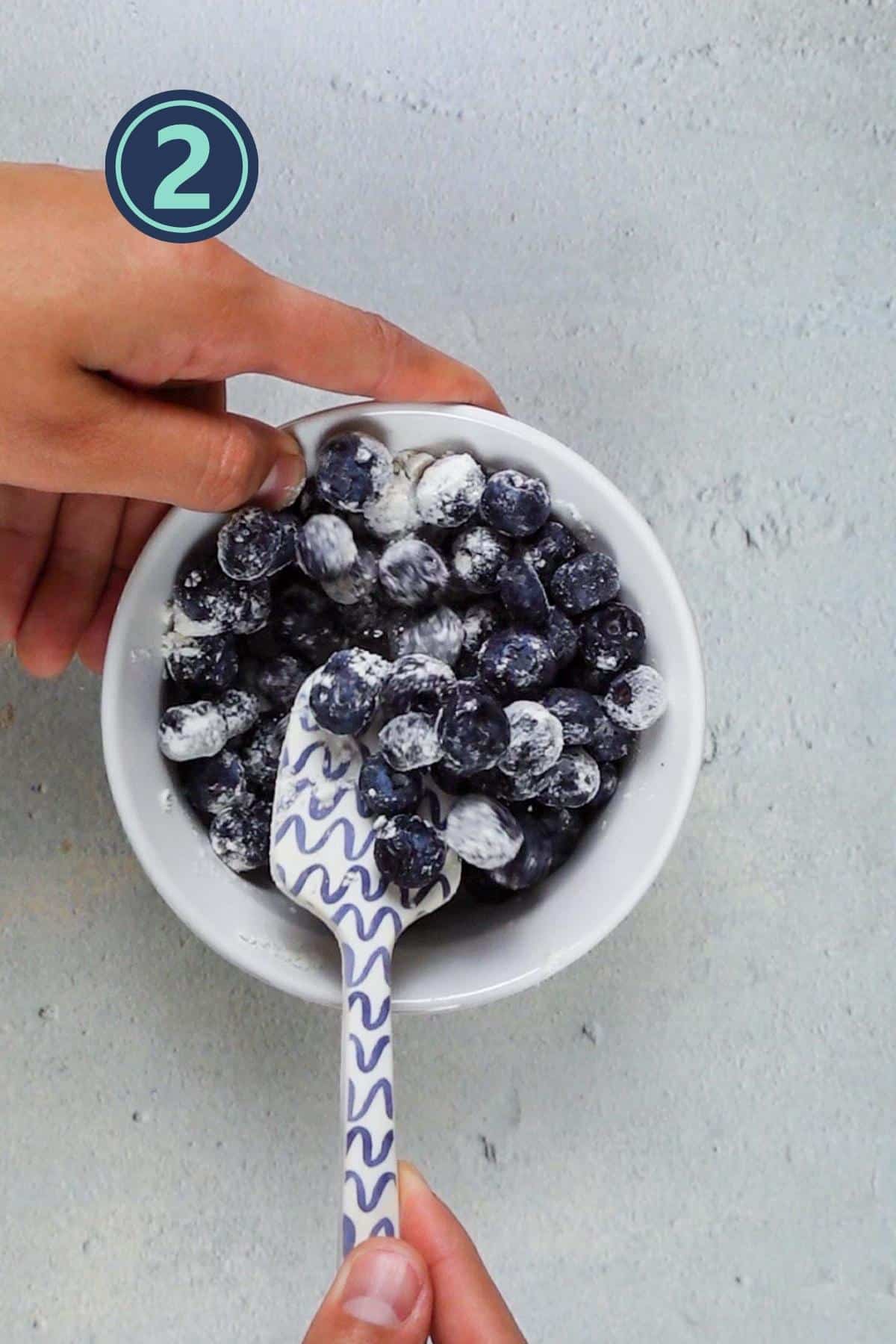 tossing the blueberries in all purpose flour.
