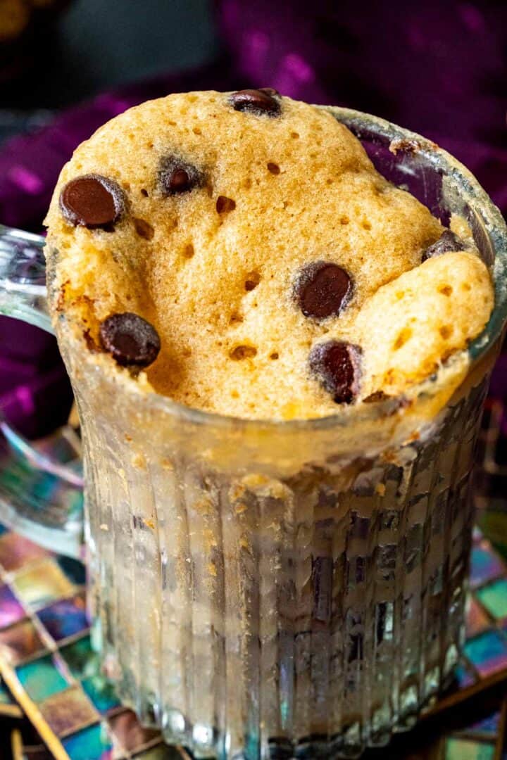 close up of chocolate chip mug cake showing the texture of the cake and chocolate chips spread on the top.